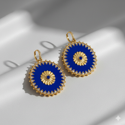 Gold and blue earrings on a light gray background