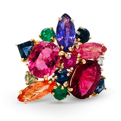 A multicolored gemstone ring with a yellow gold band, featuring various cuts and colors of gemstones. 18K gold multicolor gemstone ring flatlay – luxury fine jewelry by Tresor Collection