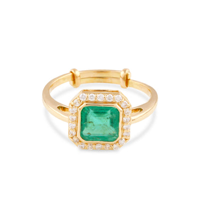 Emerald & Diamond in 18K Yellow Gold - Tresor Collection Close-up flatlay of gold emerald and diamond halo ring – luxury handcrafted fine jewelry