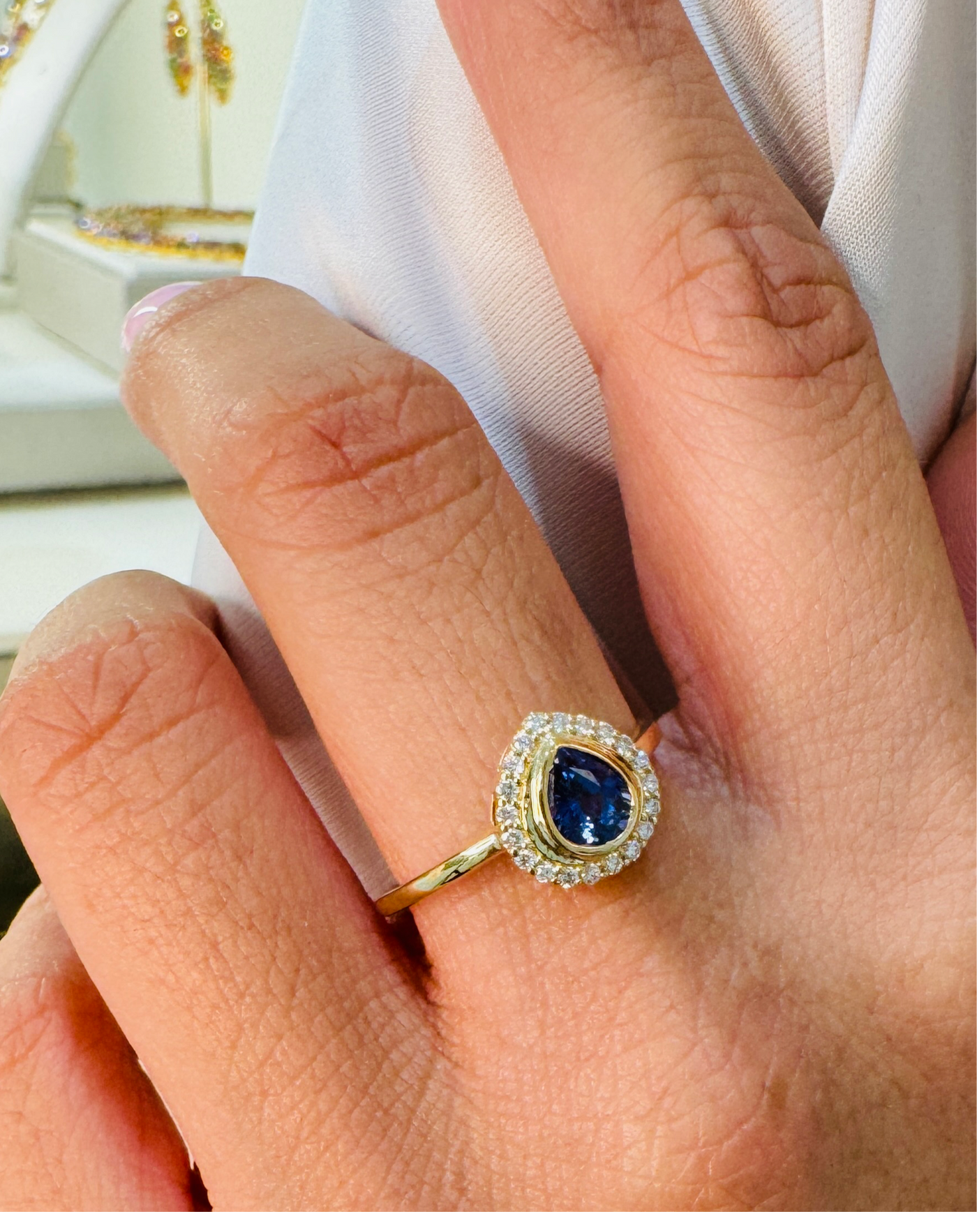 18K gold blue sapphire and diamond ring on model’s hand – elegant gemstone jewelry by Tresor Collection