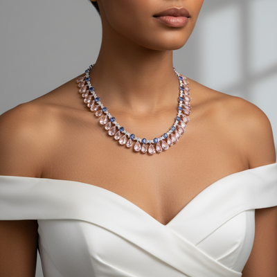 Woman wearing a necklace with a white top against a neutral background