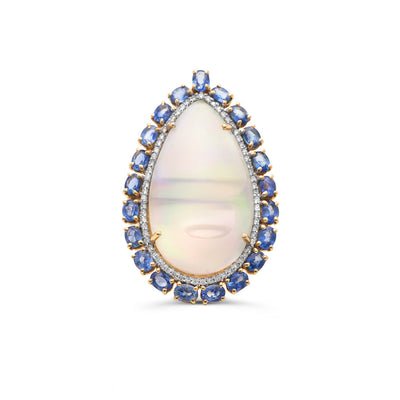 A pear-shaped opal ring with blue sapphires and diamonds set in 18K yellow gold. 18K gold Ethiopian opal and sapphire ring flatlay – luxury handcrafted jewelry by Tresor Collection