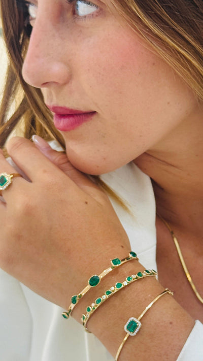 Emerald Mix Shape Bangle In 18K Yellow Gold - Tresor Collection Model wearing gold emerald bangle – close-up of the bracelet on the wrist, showcasing its beauty.