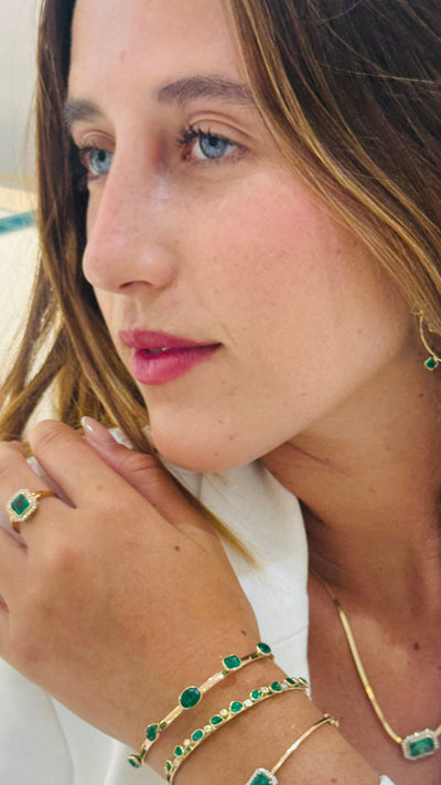 Emerald Mix Shape Bangle In 18K Yellow Gold - Tresor Collection Profile shot of the gold emerald bangle – emphasizing the bracelet’s design and vibrant green stones.