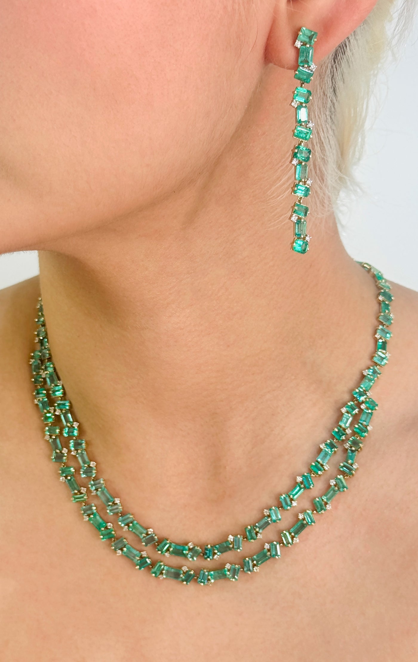 Close-up of green emerald beaded necklace on neckline – luxury gemstone jewelry by Tresor Collection