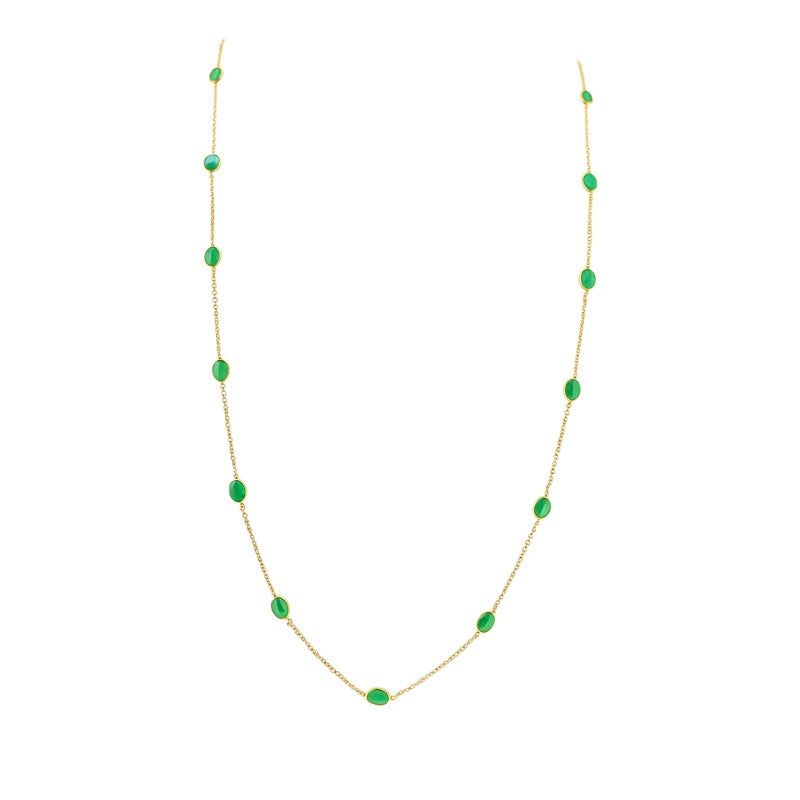 Gold necklace with green gemstones on a white background