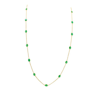 Gold necklace with green gemstones on a white background