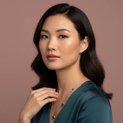 Woman wearing a necklace against a brown background Model wearing Blue Topaz station necklace – sophisticated high-end jewelry look