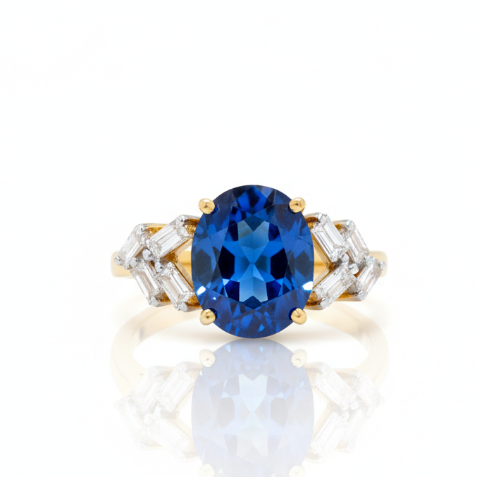 Gold ring with a blue gemstone on a white background