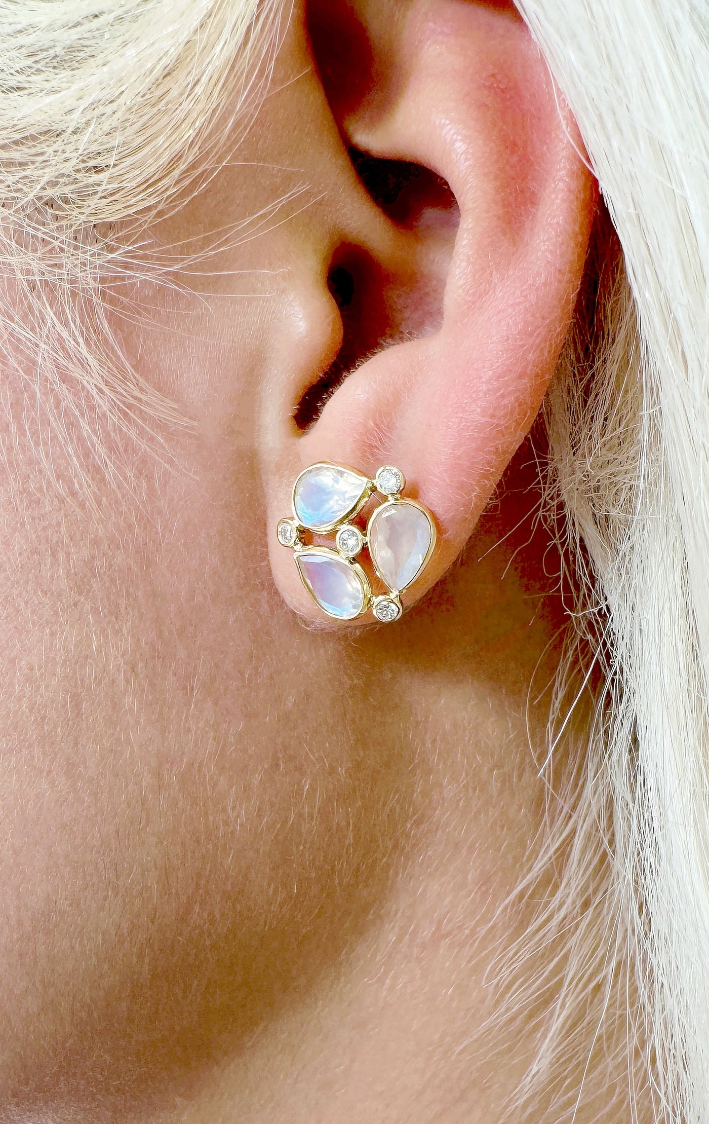 Rainbow Moonstone Pear Shape & Diamond Earring In 18K Yellow Gold - Tresor Collection Close-up of model wearing 18K gold Rainbow Moonstone stud earrings – luminous handcrafted jewelry