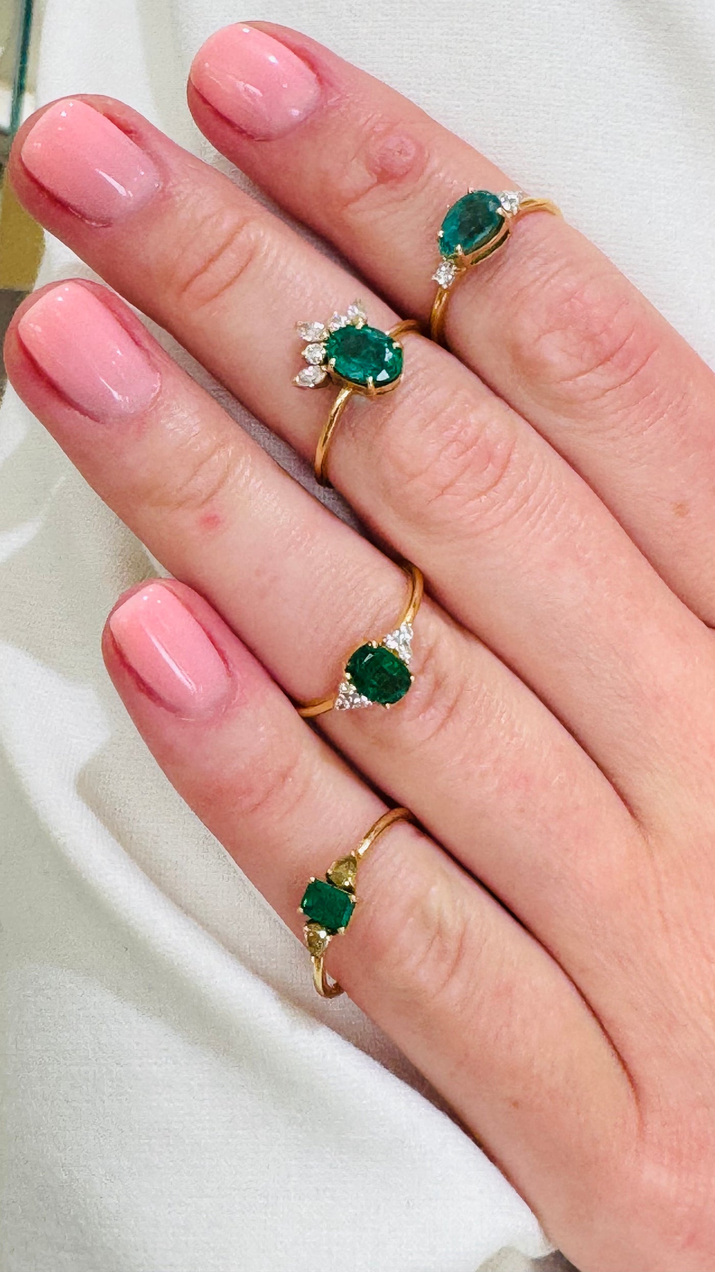 Emerald Oval & Diamond Ring In 18K Yellow Gold - Tresor Collection Emerald-cut emerald ring with pear-cut diamond accent worn on hand – delicate gold stacking ring Emerald and diamond gold ring on hand in natural light – elegant handcrafted ring