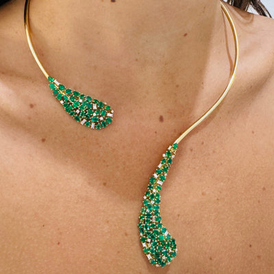 Gold necklace with green gemstones worn by a person Elegant 18K gold emerald collar necklace on model – designer fine jewelry for women by Tresor Collection