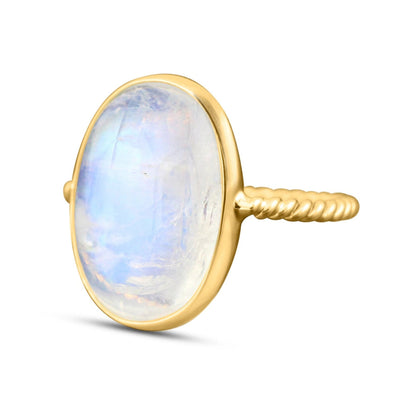 18K gold Rainbow Moonstone oval ring – luxury handcrafted fine jewelry for women 18K gold moonstone ring flatlay – luxury handcrafted jewelry with a radiant moonstone centerpiece.