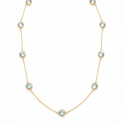 Gold necklace with crystal-like stones on a white background 18K gold aquamarine necklace flatlay – luxury fine jewelry by Tresor Collection