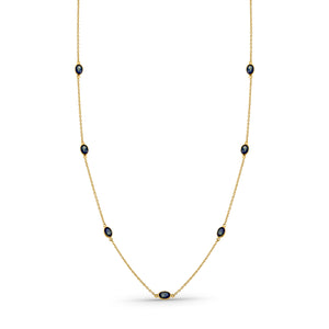 Gold necklace with black beads on a white background 18K gold blue sapphire necklace flatlay – luxury fine jewelry by Tresor Collection