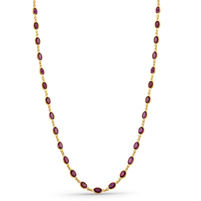 Gold necklace with red gemstones on a white background 18K gold rhodolite necklace flatlay – luxury fine jewelry by Tresor Collection