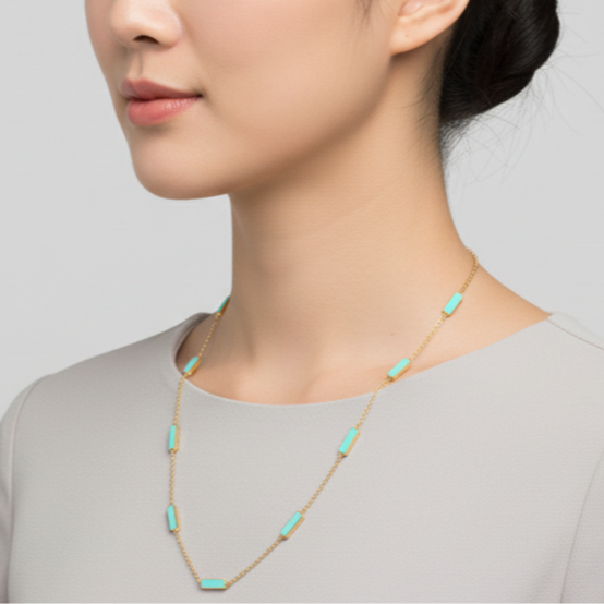 Woman wearing a necklace with turquoise stones against a plain background Elegant turquoise gold necklace on model – designer fine jewelry for women by Tresor Collection