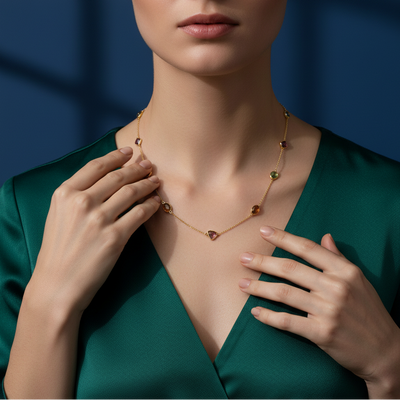Woman wearing a gold necklace with green background Elegant multicolor gemstone gold necklace on model – designer fine jewelry by Tresor Collection