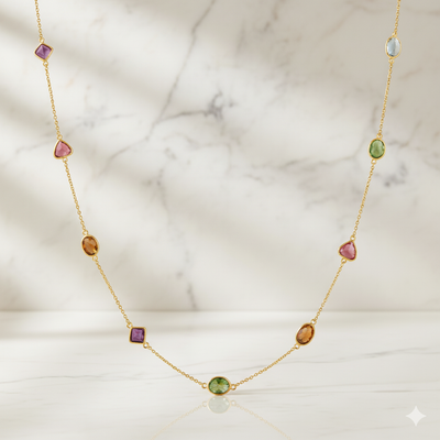 Gold necklace with multicolored gemstones on a marble background