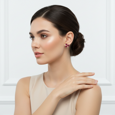 Woman wearing a necklace and earring against a white background Ruby and diamond floral earrings styled for festive and gifting occasions – luxury handcrafted jewelry from Tresor Collection